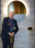Poet Mike Subritzky in front of ANZ memorial plaque.
